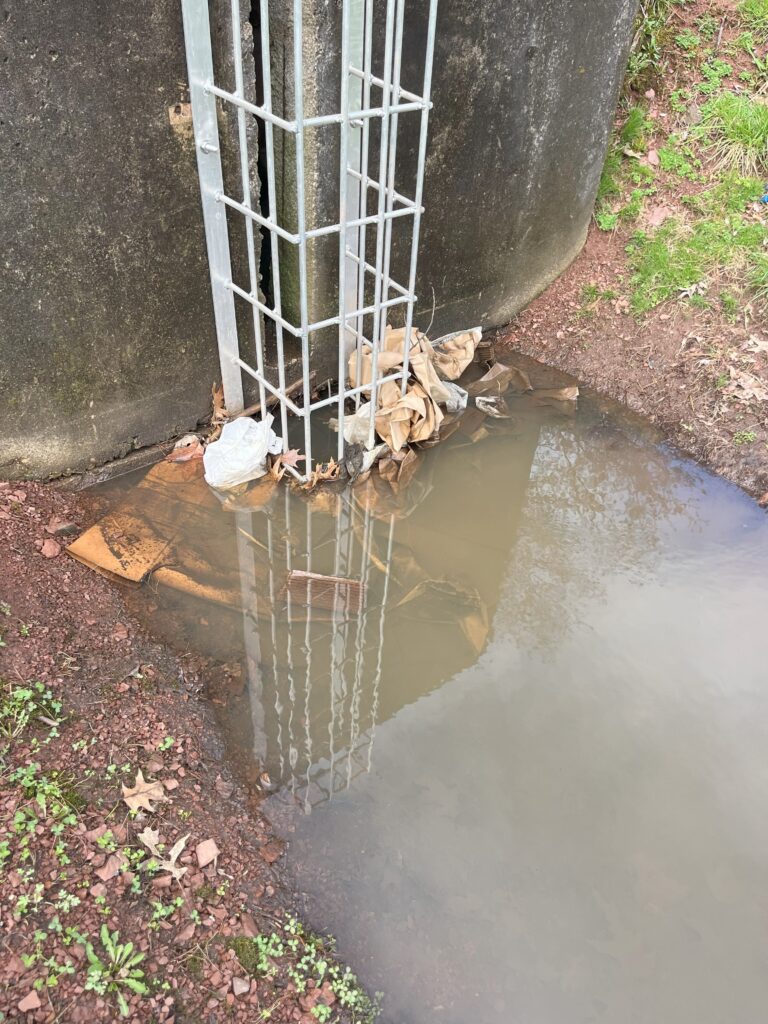 Culvert outlet control structure with metal grate, designed for stormwater management and to prevent debris clogging.