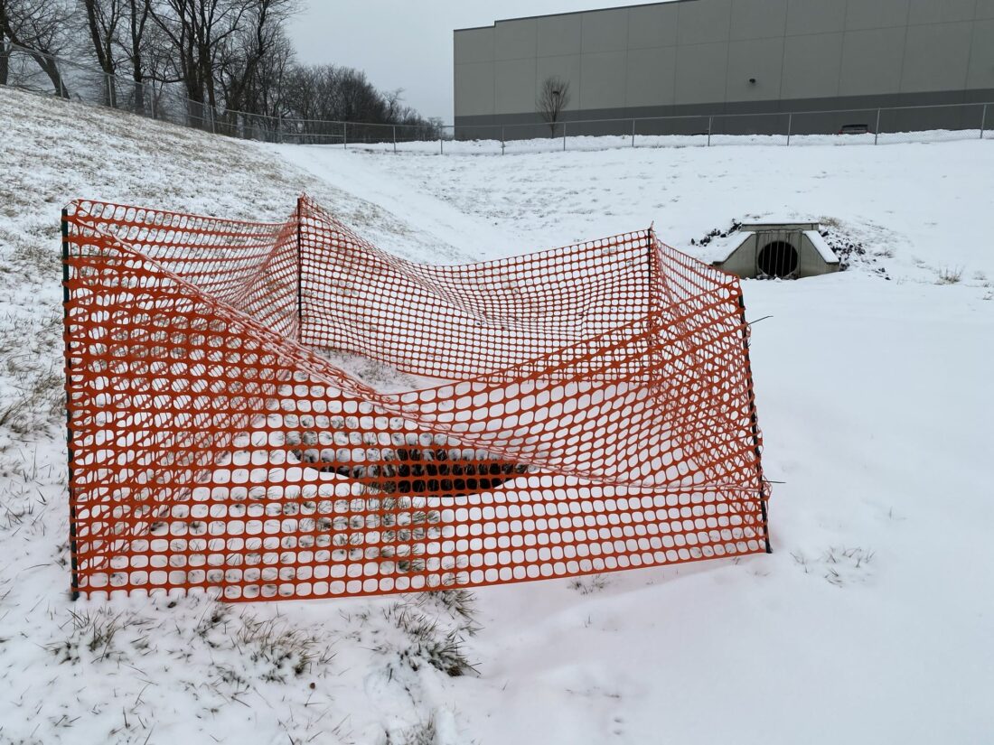 Snow-covered sinkhole area with safety barriers, emphasizing sinkhole remediation during winter in Pennsylvania