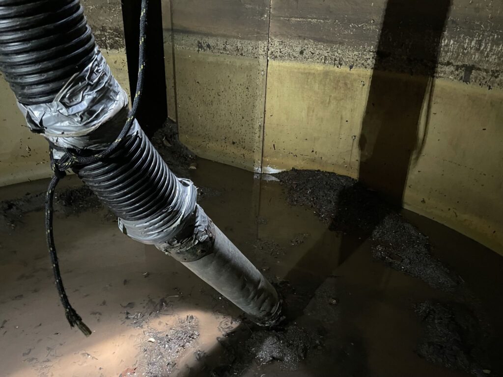 Close-up of a stormwater manufactured treatment device showing a pipe installation during inspection.